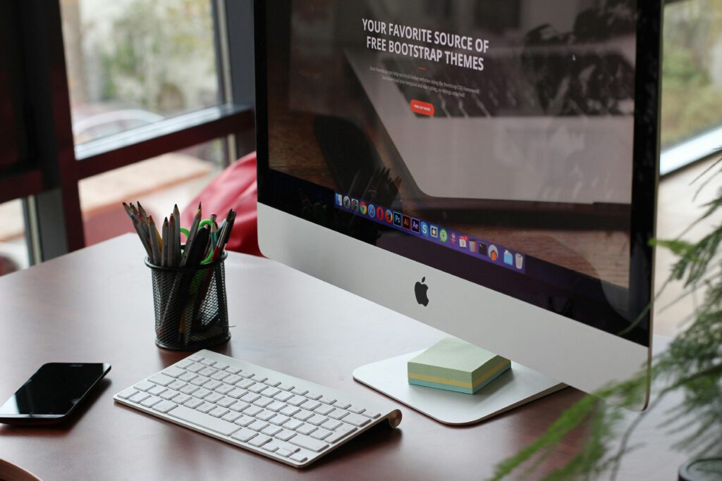 An iMac desktop computer on a tidy desk by a window