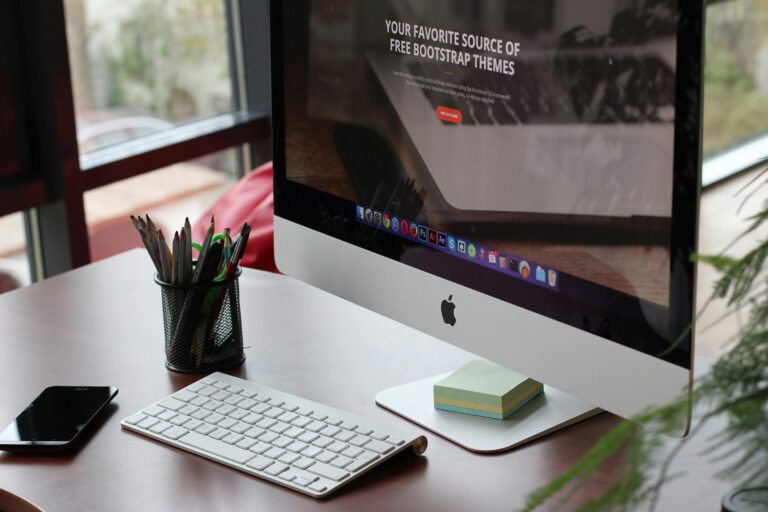 An iMac desktop computer on a tidy desk by a window