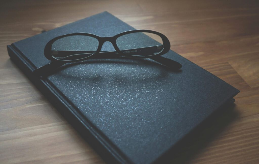 A pair of eyeglasses resting on a closed notebook