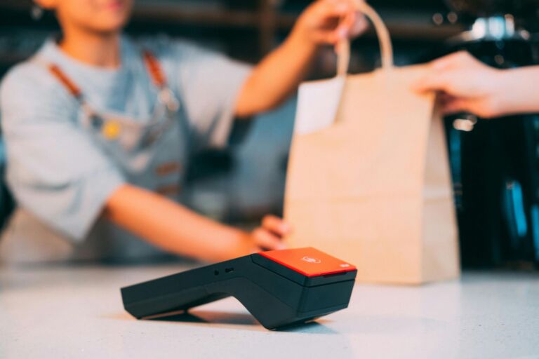 A customer paying by card while collecting a takeout order