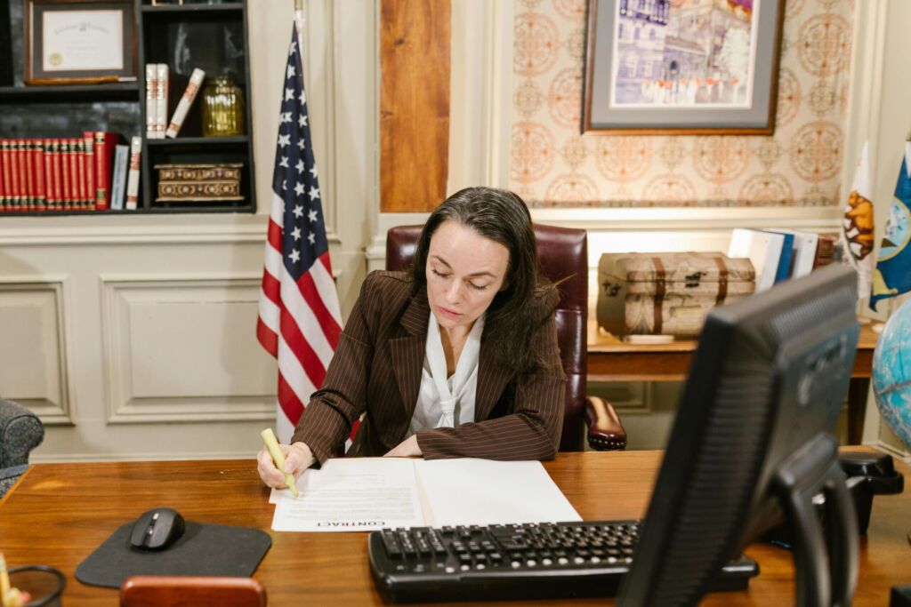 A professional working at a desk in an office with an American flag