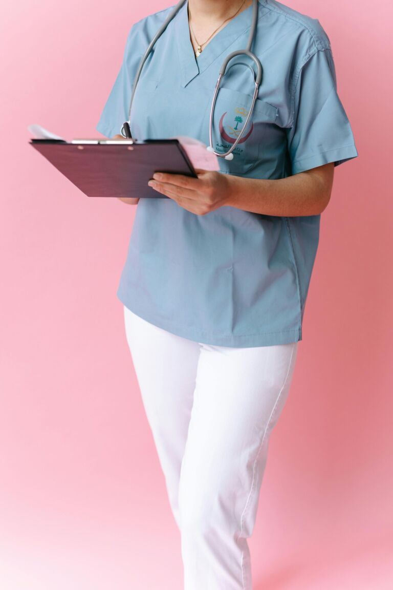 A nurse in scrubs holding a clipboard
