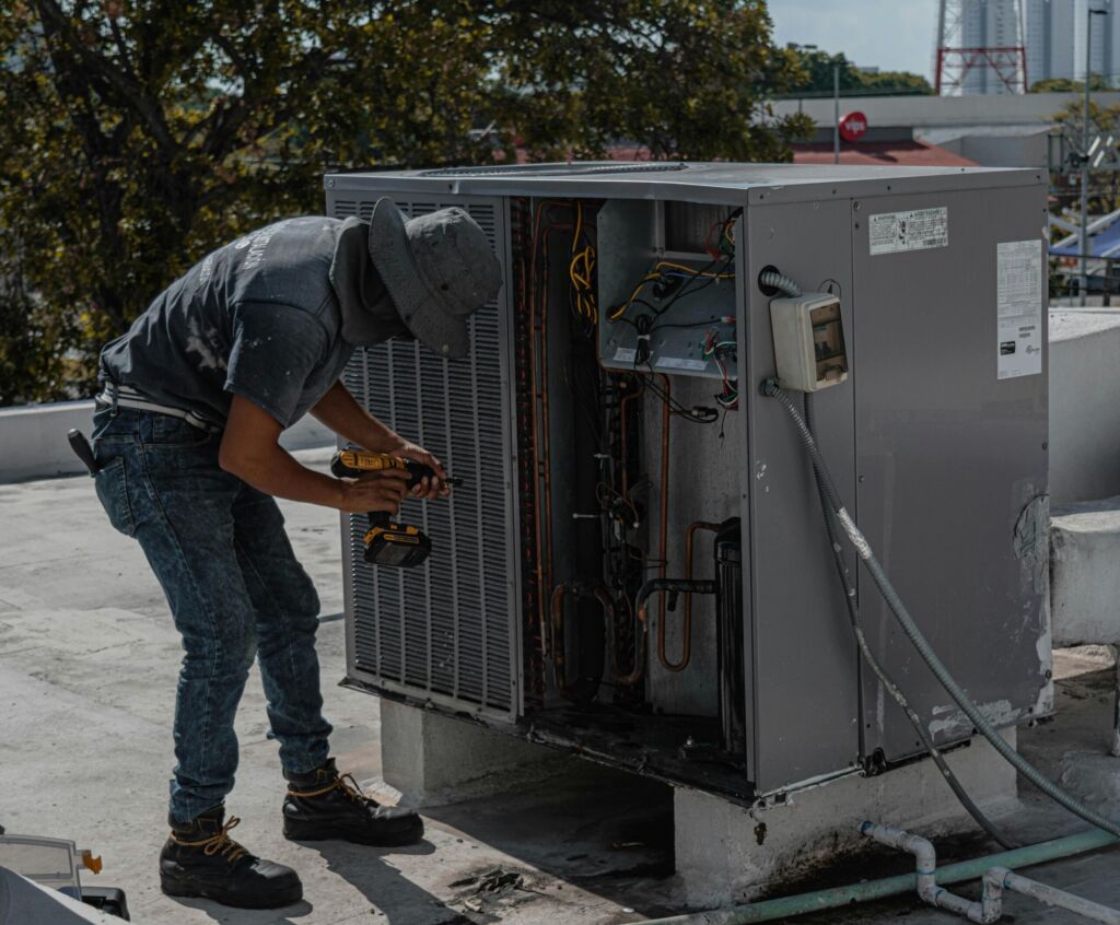 A technician repairing a rooftop HVAC unit