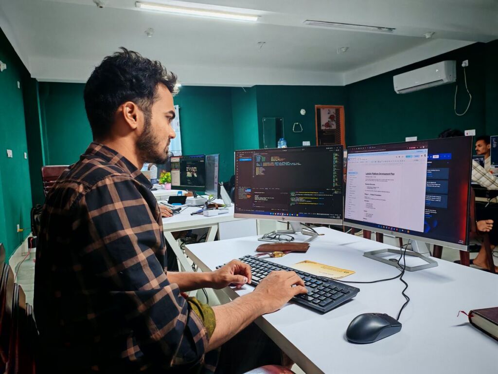 Software developer working at a dual-monitor setup