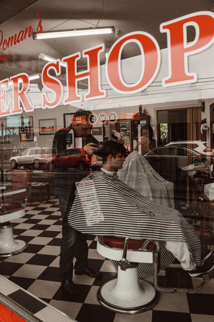 Barber cutting a client's hair in a barber chair