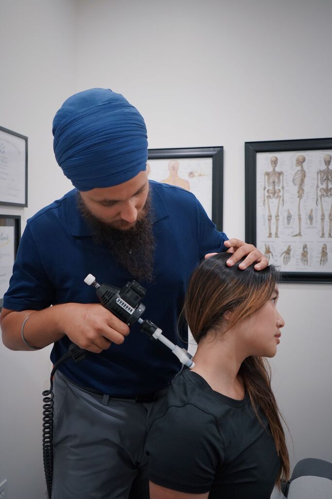 Chiropractor performing a gentle neck adjustment on a seated patient