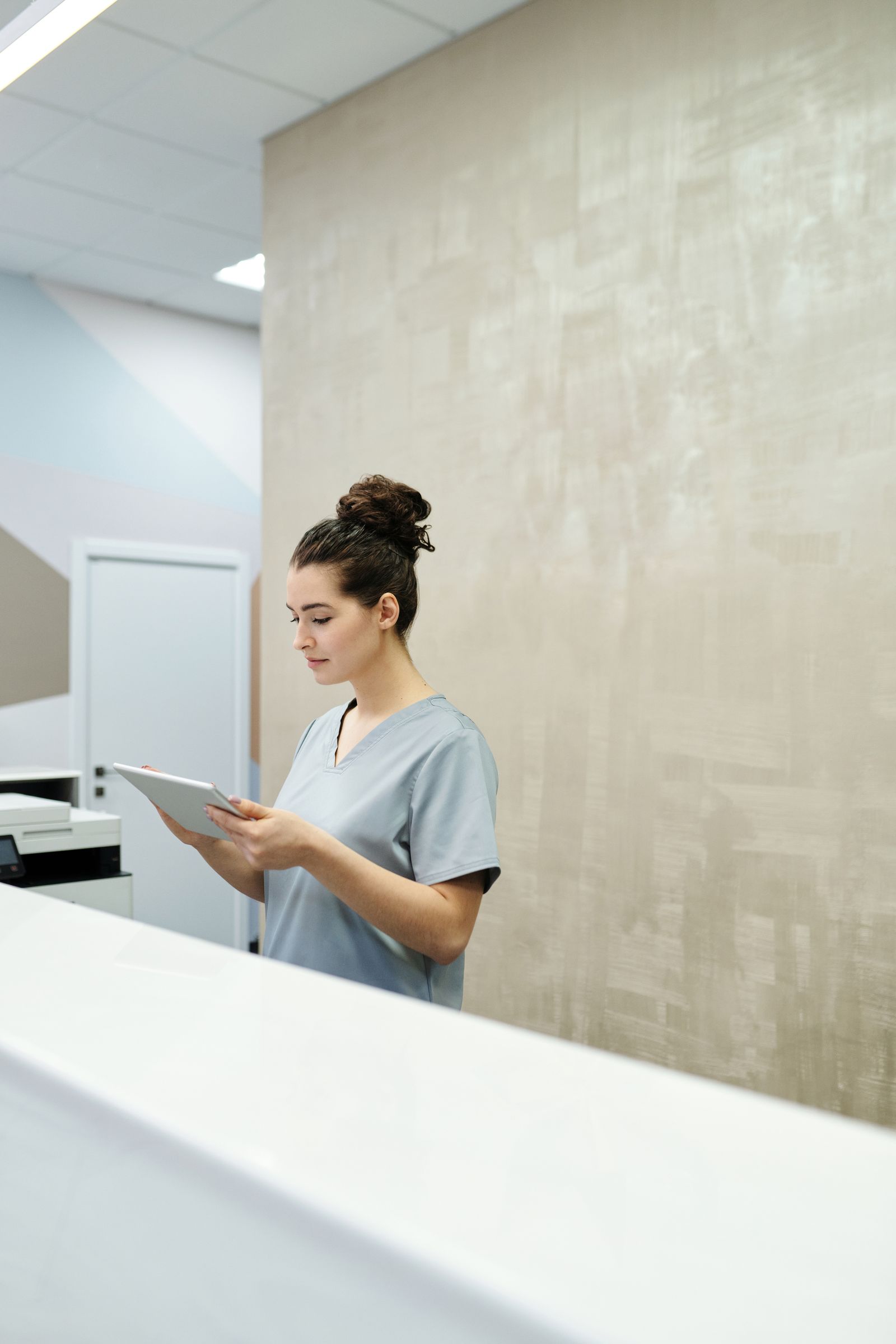 Medical receptionist reviewing patient information on a tablet
