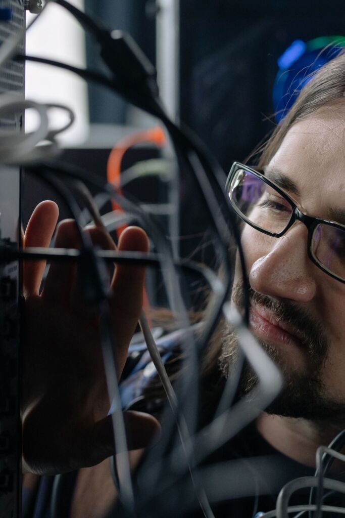 IT technician connecting network cables in a server rack