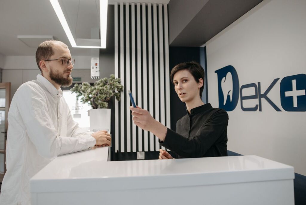 Receptionist assisting a patient at a medical practice front desk