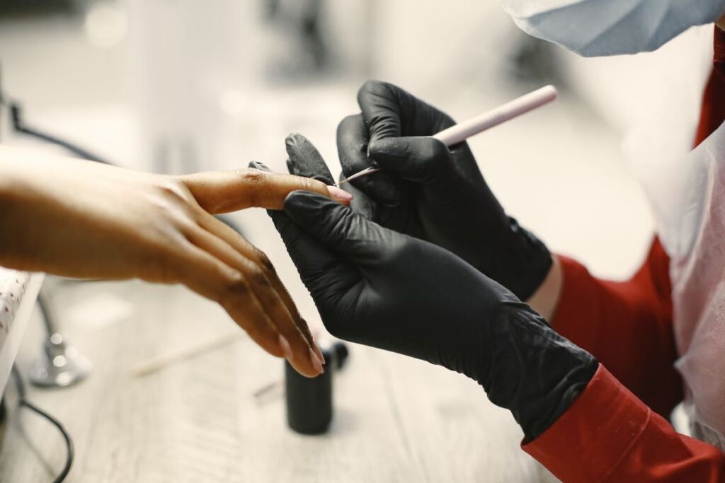 Manicurist giving a client a manicure at a nail salon