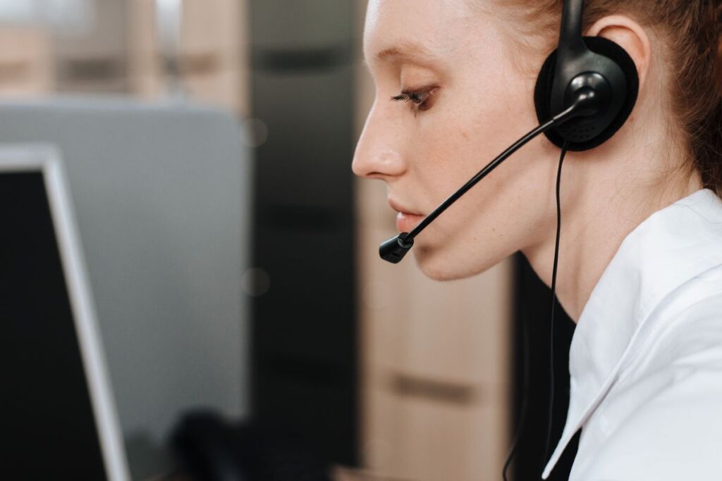 IT support agent wearing a headset at a help desk